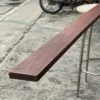 red-hardwood-timber-stacked กองไม้แดงแปรรูปวางเรียงซ้อนกันเป็นชั้น แสดงลักษณะไม้เนื้อแข็งสำหรับงานก่อสร้างและเฟอร์นิเจอร์
