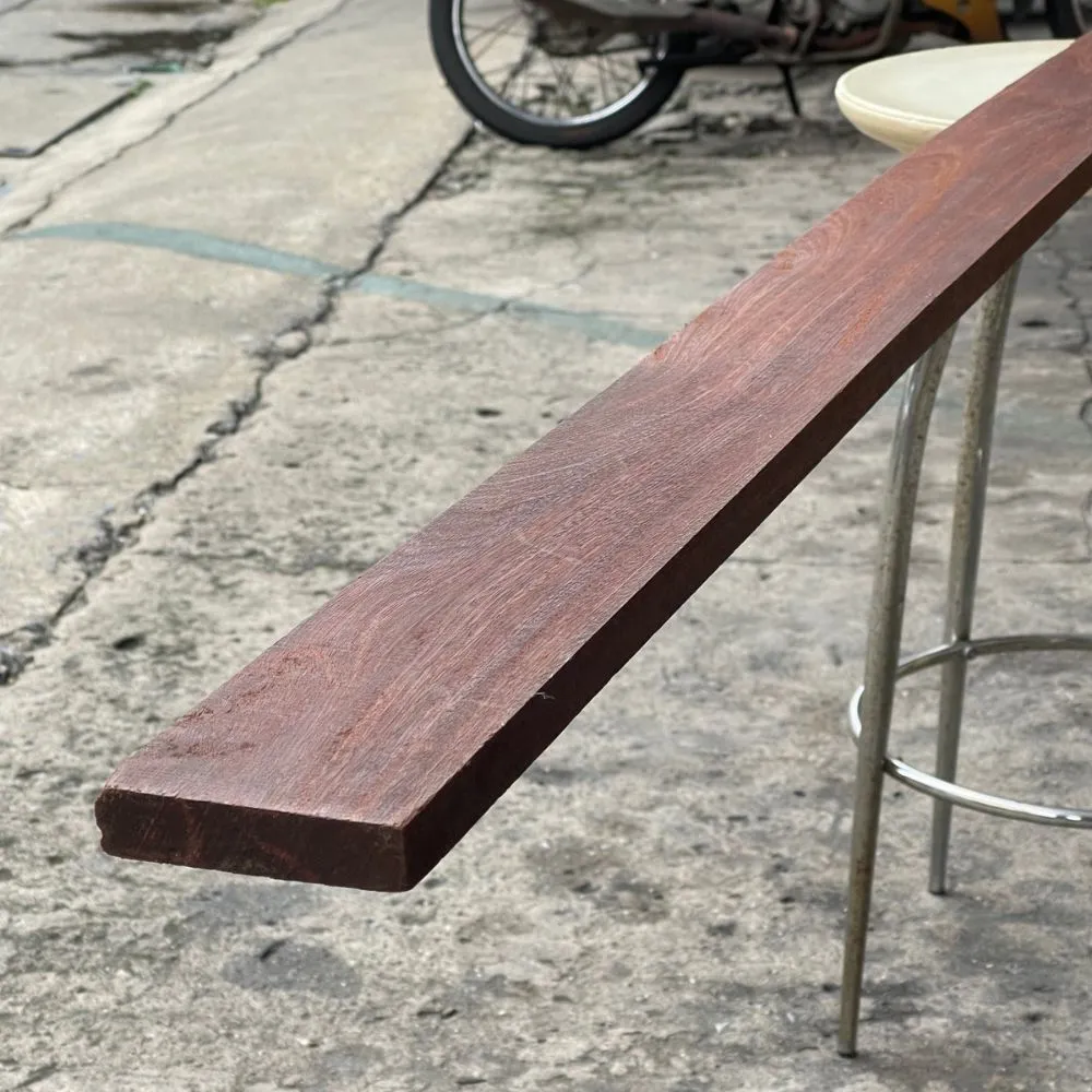 red-hardwood-timber-stacked กองไม้แดงแปรรูปวางเรียงซ้อนกันเป็นชั้น แสดงลักษณะไม้เนื้อแข็งสำหรับงานก่อสร้างและเฟอร์นิเจอร์
