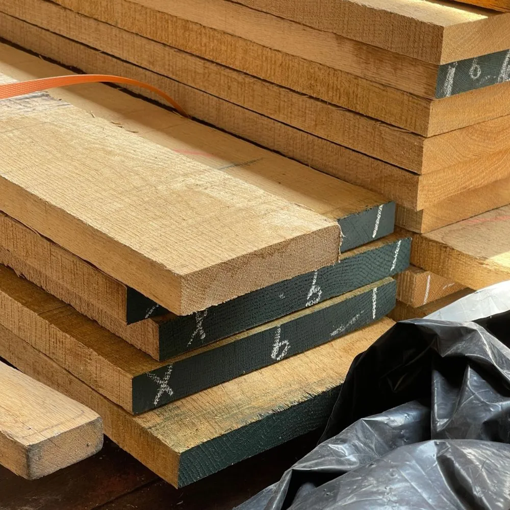 real-oak-lumber-wood-grain กองไม้ท่อนโอ๊ควางเรียงซ้อนกันเป็นชั้น แสดงลักษณะไม้โอ๊คสำหรับงานแปรรูปและผลิตเฟอร์นิเจอร์